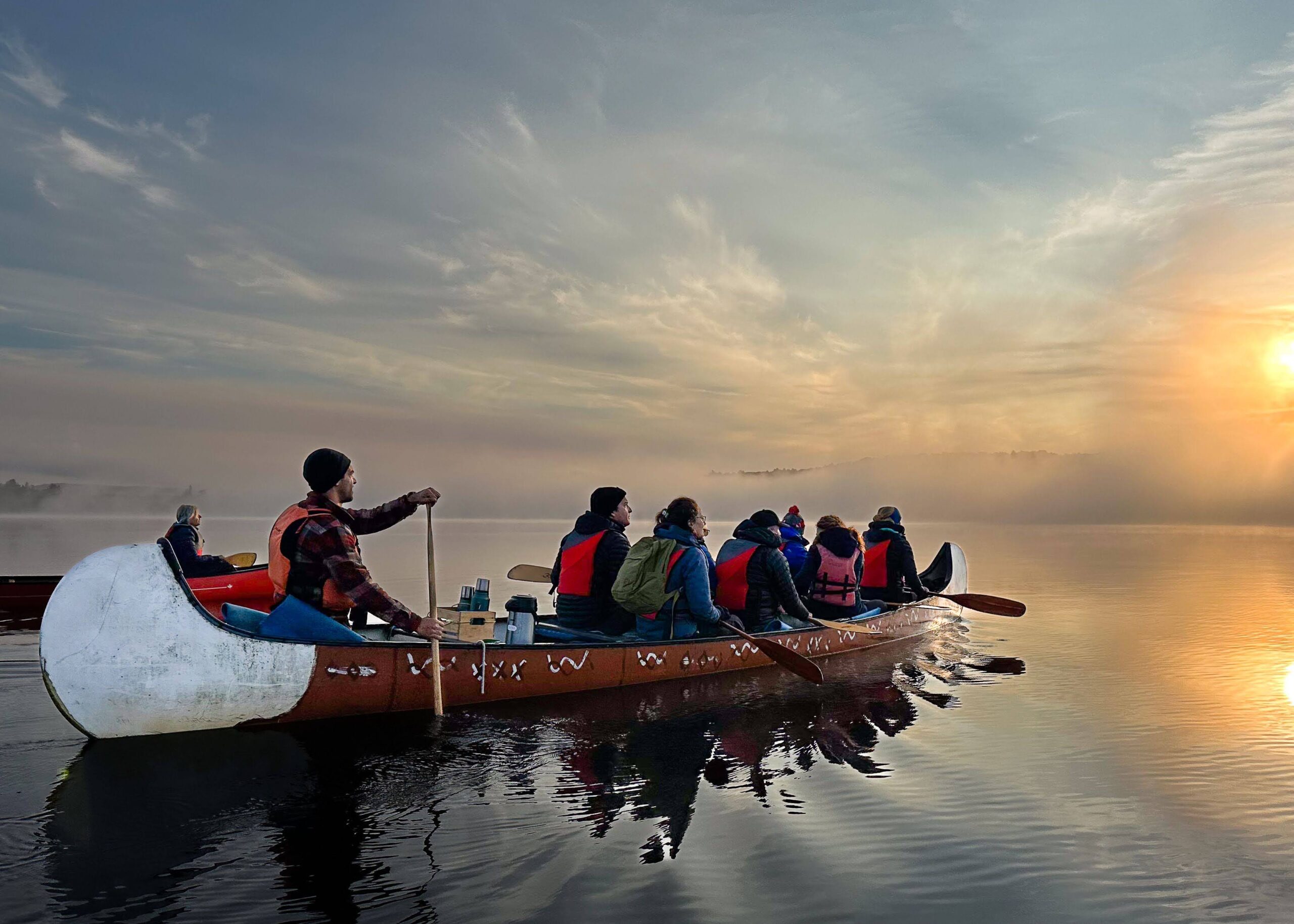Group canoeing on a big canoe at Voyageur Quest - Resorts of Ontario