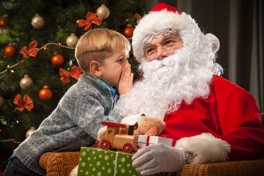 Image of a boy whispering to Santa at Fern Resort - Resorts of Ontario