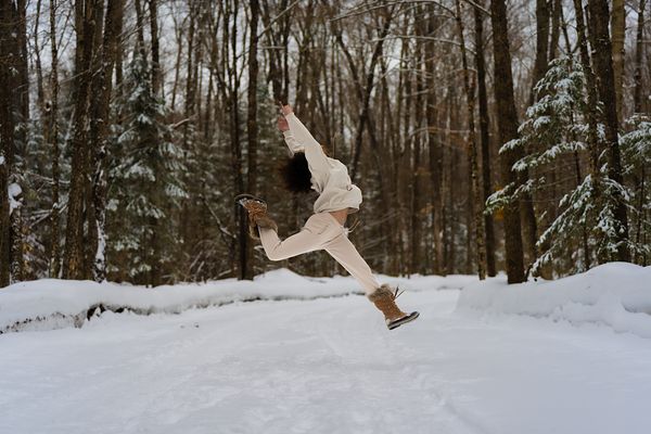 Image of a lady jumping outside at Dimension's Retreats - Resorts of Ontario