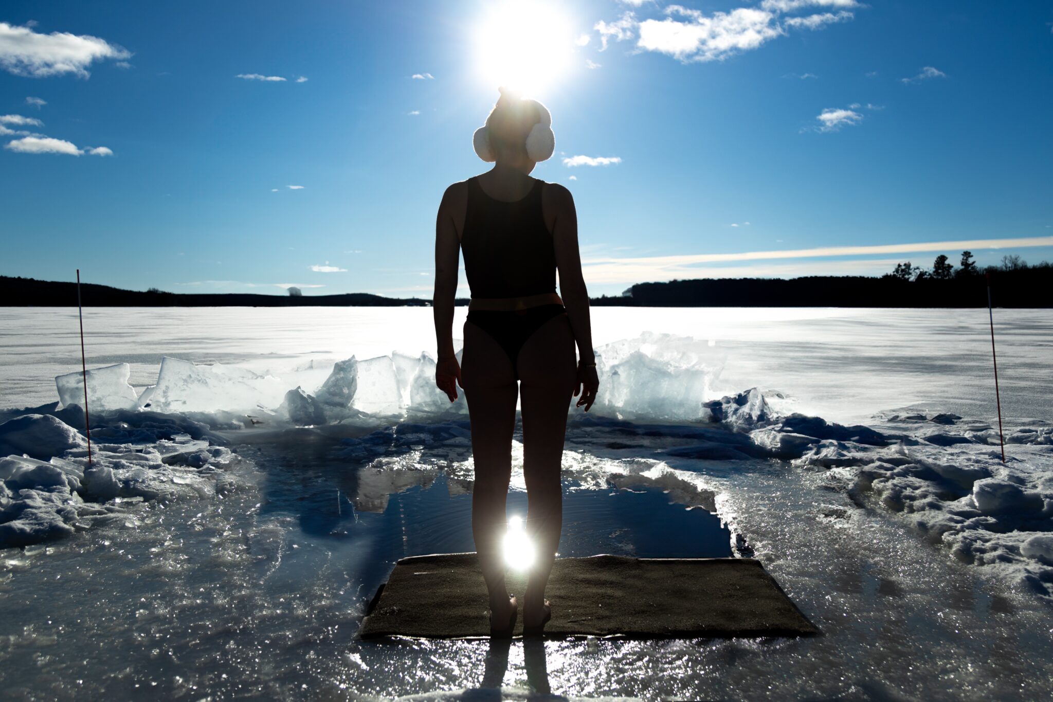 Image of a woman about to do a cold plunge on the frozen lake at Dimensions Retreats - Resorts of Ontario